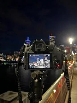 A camera on a tripod captures a night view of Vancouvers skyline, with the .. Stock Photos