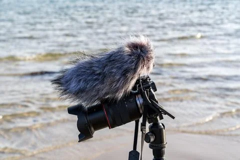A camera is on a tripod close-up on a beach Stock Photos
