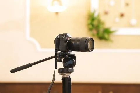 Camera on tripod in indoor setting for taking photos Stock Photos