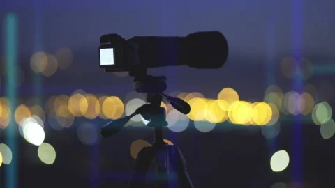 The camera with tripod stand by night city holographic background Stock Footage 133720067