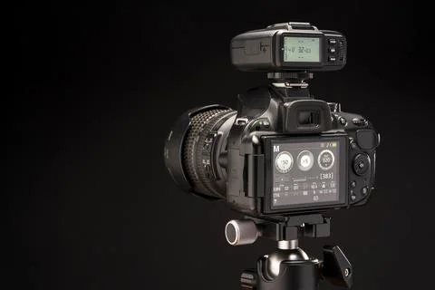 Camera is turned on with a flash synchronizer on a black background Stock Photos