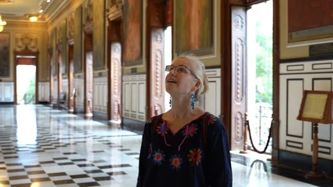 Camera turns to the left around a smiling mature tourist woman in ethnic clothes Stock Footage 129887782