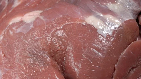 Camera turns over fresh pork meat at bright light macro Stock Footage 124668656