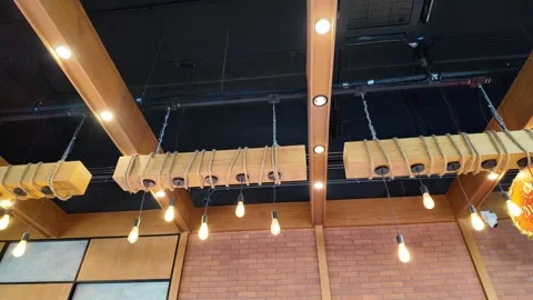 Camera video of ceiling with decorative hanging lights in a café interior Stock Footage 325648907
