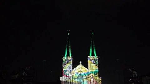 Camera video of colorful light projection on cathedral facade at night Stock Footage 325559563
