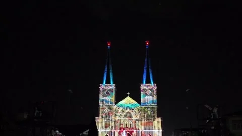 Camera video of colorful light projection on cathedral facade at night Stock Footage 325559714