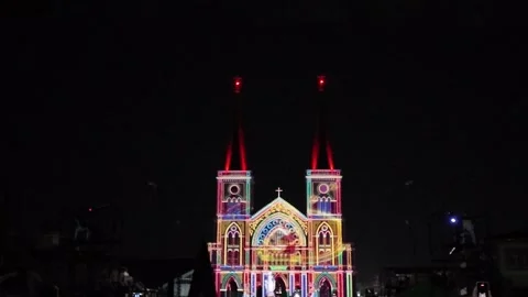 Camera video of colorful light projection on cathedral facade at night Stock Footage 325649113