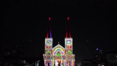 Camera video of colorful light projection on cathedral facade at night Stock Footage 325649114