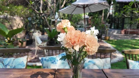 Camera video of flower vase on table in outdoor cafe Stock Footage 325560875