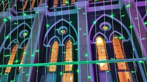 Camera video of gothic church windows illuminated with colorful lights at night Stock Footage 325650121