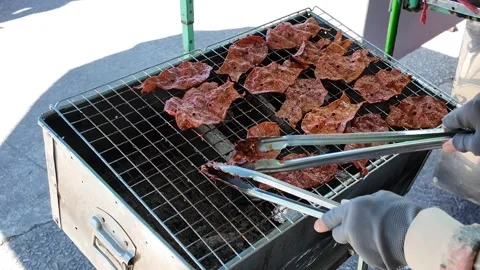 Camera video of grilled dried meat on charcoal stove Stock Footage 325650565