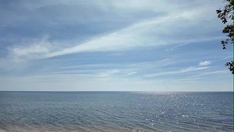 Camera video of tranquil sea with sunlight reflection under blue sky Stock Footage 325650154