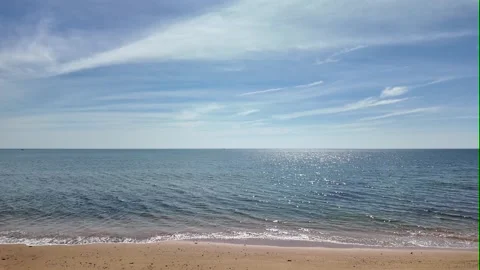 Camera video of tranquil sea with sunlight reflection under blue sky Stock Footage 325650161