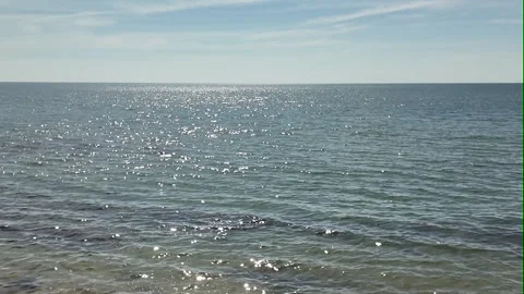 Camera video of tranquil sea with sunlight reflection under blue sky Stock Footage 325650208