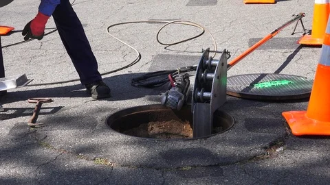 Camera view of  city sewer, man lowers camera into sewer Video stock 108557265