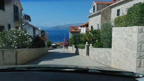 Camera view from a driving car descending downhill towards the sea Stock Footage 160552542