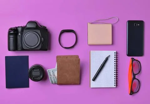 Camera, wallet, notebook, glasses, and accessories on pink background Stock Photos