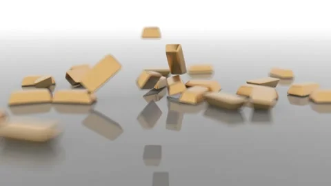 The camera watches as ingots of gold fall from top to bottom onto a glossy gray Video stock 164704180