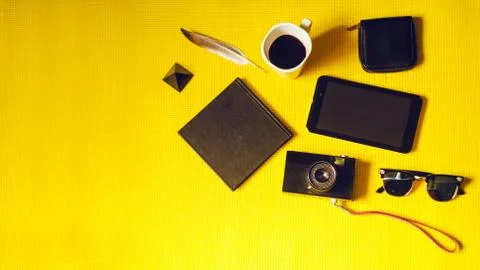Camera while on vacation. notepad, purse, glasses, tablet. yellow background. Fotos Stock
