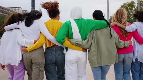 Camera zoom rear view of Gen Z group only women friends walking hugging enjoying Stock Footage 316923532