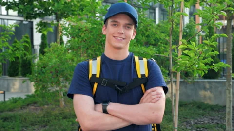Camera zoom in smiling young man courier food delivery with thermal backpack Stock Footage 157603254