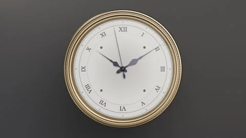 Camera zooming, analog clock with gold rim filling frame on dark wall, hands Stock Footage 337505096