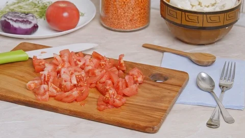 The camera zooming to a cutting board with chopped tomatoes. Stock Footage 120159524