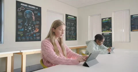 Camera zooming, Diverse teens studying at table, typing tablet, scrolling phone, Stock Footage 340898604