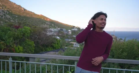 Camera zooming, Hispanic man leaning on metal railing, scanning hillside homes, Stock Footage 335866743