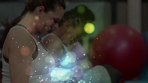 Camera zooming in on prenatal class participant curling dumbbells during fitness Stock Footage 313570900