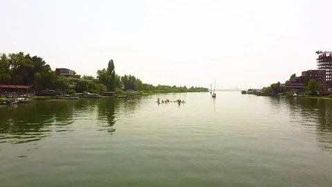 The camera zooms in to a group of people doing paddle yoga in the water Stock Footage 135830795