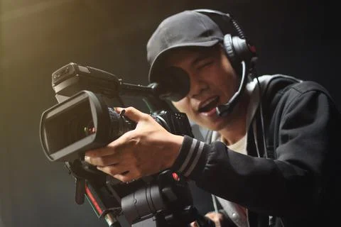 Cameraman with a camera on a tripod at studio Stock Photos