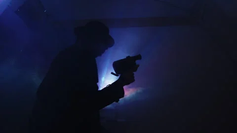 Cameraman capturing stunning light rays silhouette at evening event Stock Footage 319946964