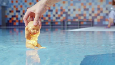 Cameraman dips doll into water and adjusts beam of light Stock Footage 228781092