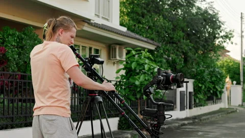 Cameraman filming on a camera mounted on a crane outside against the backdrop of Stock Footage 240650878