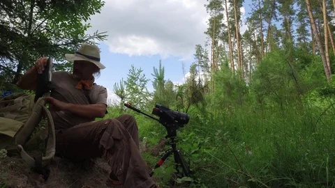 Cameraman in Forest: Mature man records a insect identification data on a tablet Stock Footage