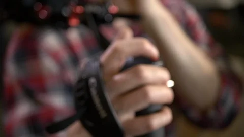 Cameraman hands on handgrip operating an EOS Canon C300 Mark II video camera. Stock Footage 99426525