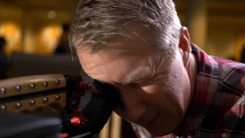 A cameraman operates a video camera putting eye to eyecup. Stock Footage 99426469