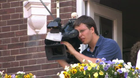 Cameraman setting up his camera Stock Footage 777923