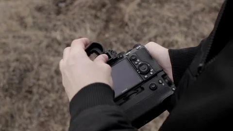 Cameraman is setting mirrorless camera before the set viewfinder Stock Footage 124118119