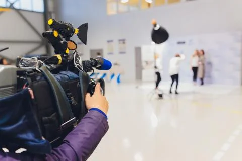 Cameraman using black professional digital video camera. Outdoor setup and Stock Photos