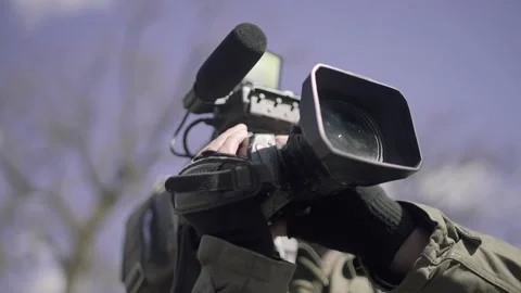 Cameraman with a video camera on his shoulder shoots a report Stockbeeldmateriaal 195219658