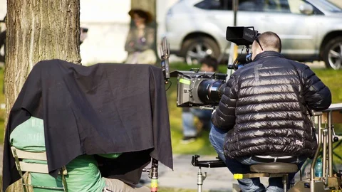 Cameraman wearing jacket working at camera Stock Footage 128983443