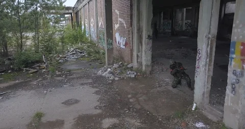 Camouflage guy aiming behind corner Stock Footage 114315625