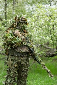 Camouflaged sniper in the forest Stock Photos
