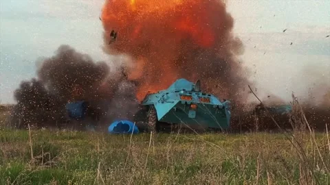 Camouflaged tank firing and exploding on a rural test field Stock Footage 313255445
