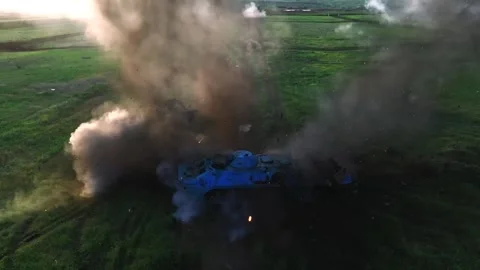 Camouflaged tank firing and exploding on a rural test field Stock Footage 313255452