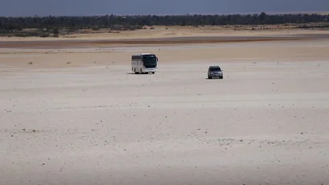 Camp car and bus walking on the sand under the hot sky in the desert - Stock Footage 240993749