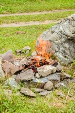 Camp fire. Bonfire diluted in the rocks against the background of the forest Stock Photos
