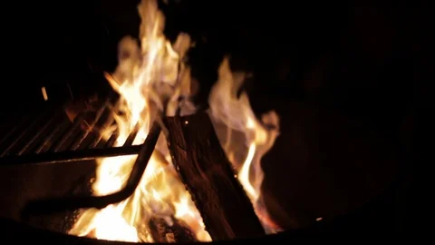 Camp fire burns logs under a grill at a campsite Video stock 91276222